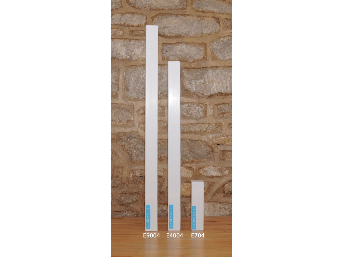 Three white Geomack energetic vitalisers labeled E9004, E4004, and E704 standing against a stone wall