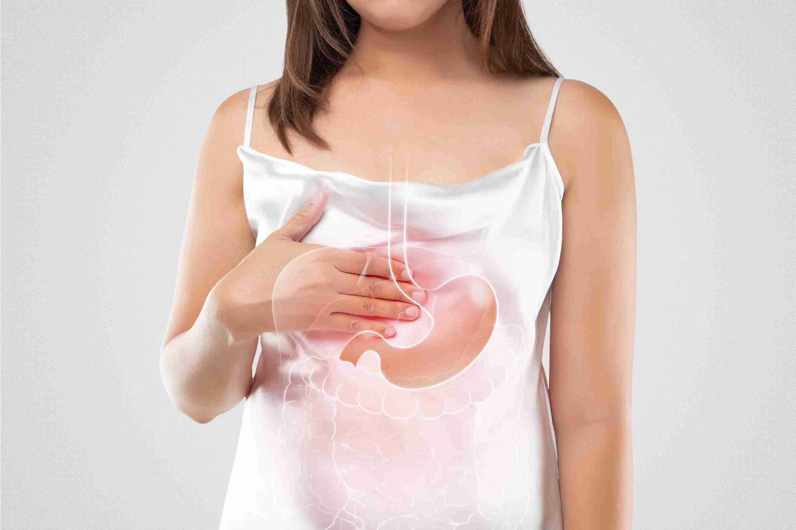 Woman holding her stomach because of acid reflux.