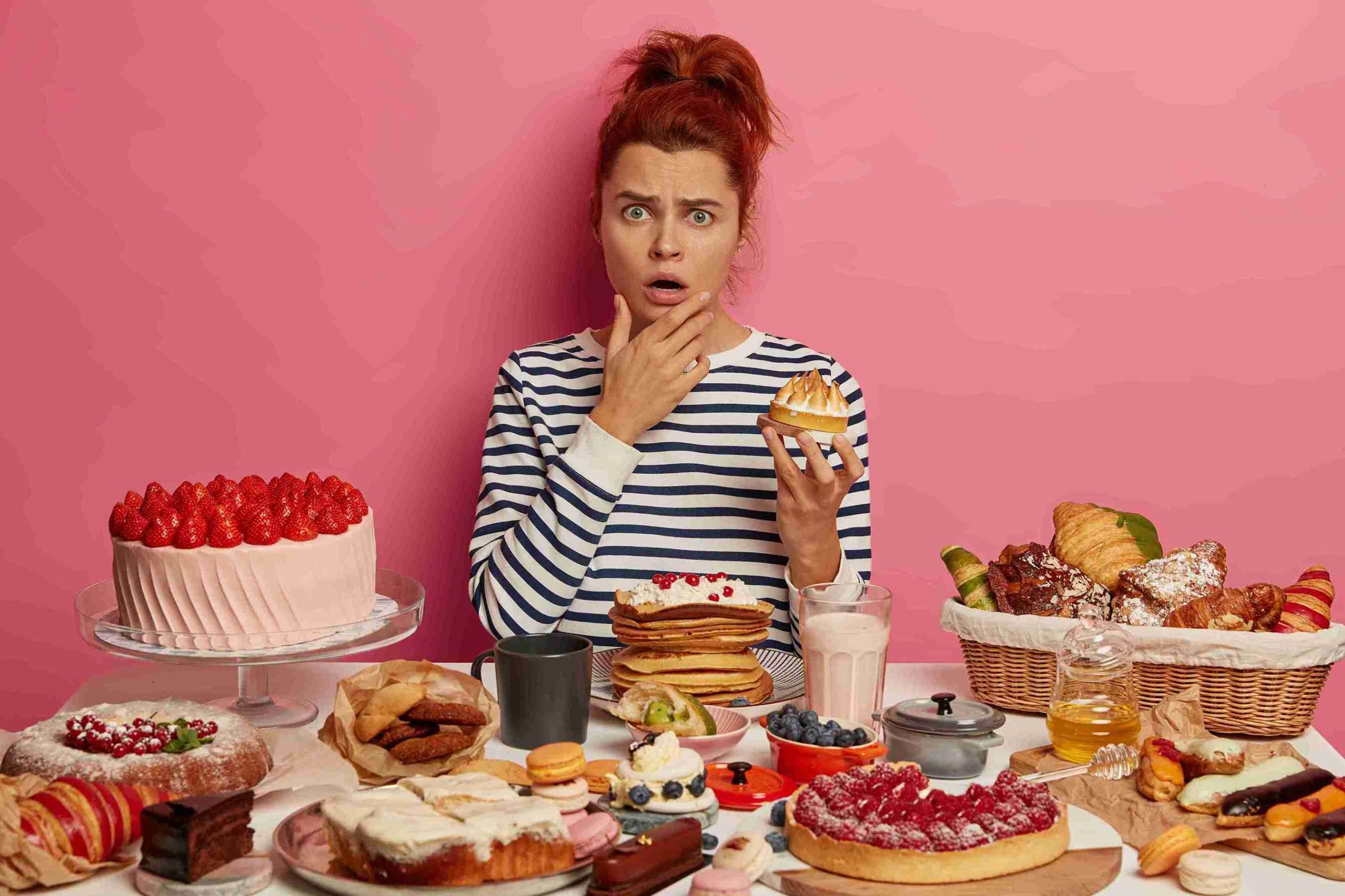 Woman with various food items looking confused.