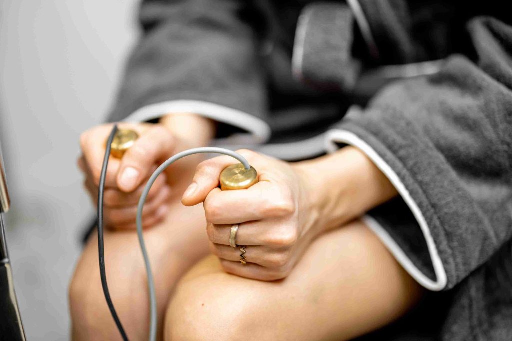 Image of a woman's hands holidng bioresonance therapy sensors.